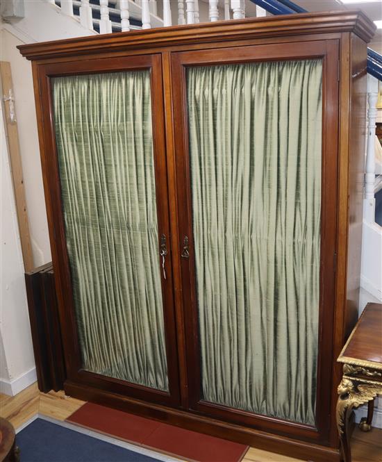 A late Victorian mahogany glazed two door bookcase with pleated fabric interior W.173cm